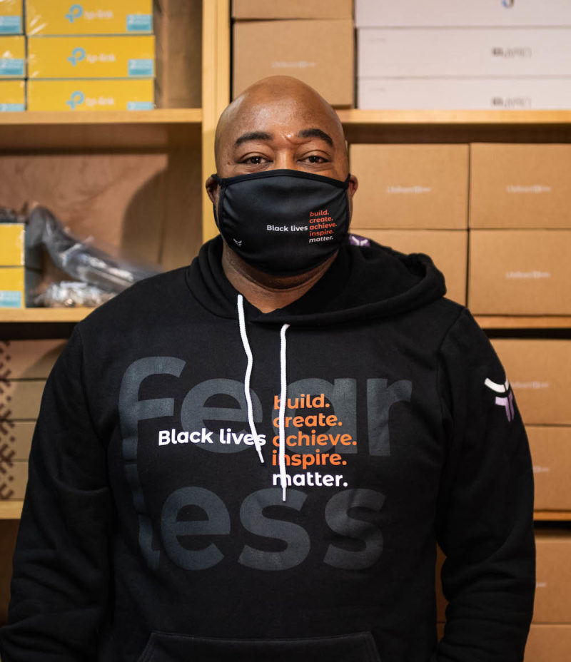Jonathan in fearless BLM mask and hoodie in front of shelves
